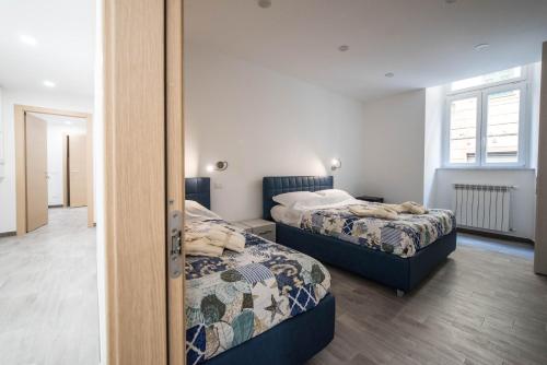 sypialnia z dwoma łóżkami i lustrem w obiekcie 5 Terre Lodge w mieście La Spezia