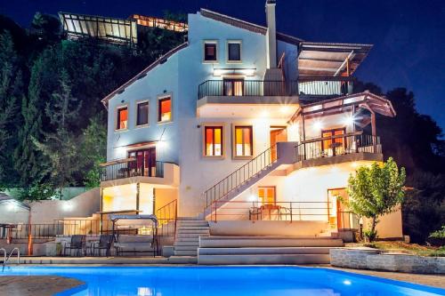 a house with a swimming pool in front of it at Estate Kares in Tílisos