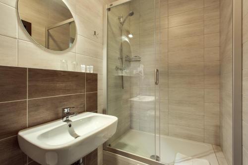 a bathroom with a white sink and a shower at Old Town Trio in Vilnius