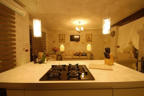 a kitchen with a stove and a living room at King Apart By Traveller's in Goreme