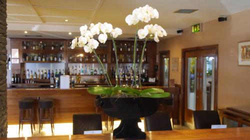 a vase with white flowers on a table in a bar at The Big Blue Hotel - Blackpool Pleasure Beach in Blackpool