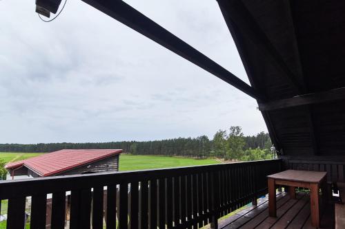a balcony with a view of a green field at Gospodarstwo Agroturystyczne Antoniewo in Antoniewo