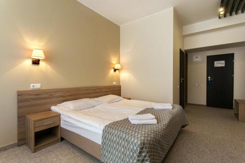 a bedroom with a bed with two towels on it at Old Town Trio in Vilnius