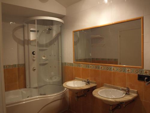 y baño con 2 lavabos, ducha y bañera. en Hotel Lastres Miramar, en Lastres