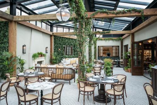 an outdoor patio with tables and chairs and plants at The Gleneagles Hotel in Auchterarder