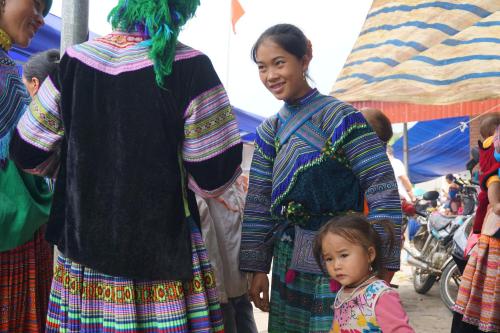 a woman and a little girl standing next to a group of people at Huy Trung Homestay in Bắc Hà