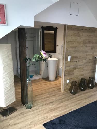 a vase with flowers in a room with shoes at Hotel Heddernheimer Hof in Frankfurt