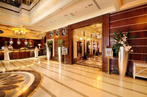 un vestíbulo de un hotel con jarrones de flores en Ruve Al Madinah Hotel, en Medina