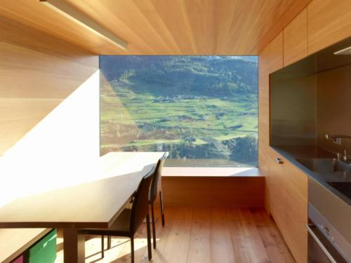 a kitchen with a table and a large window at Chalet Le Biolley in Orsières