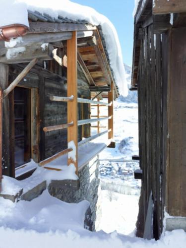 a cabin in the snow with snow on the roof at Chalet Le Biolley in Orsières