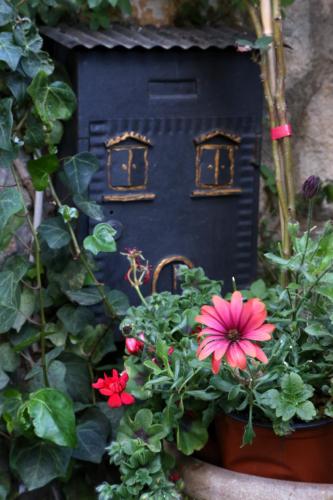 a bird house with flowers in a garden at Kimera in Piazza Armerina