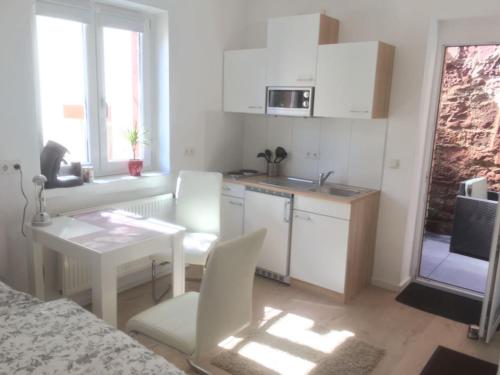 a small kitchen with a table and chairs and a table at Wohnen im Springerhof in Lohr
