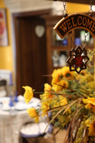 a welcome sign is hanging over a table with yellow flowers at Kimera in Piazza Armerina
