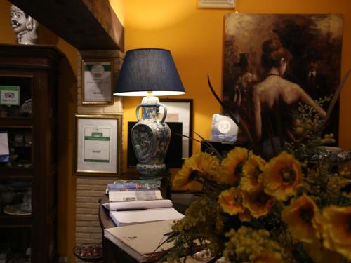 a table with a lamp and flowers in a room at Kimera in Piazza Armerina