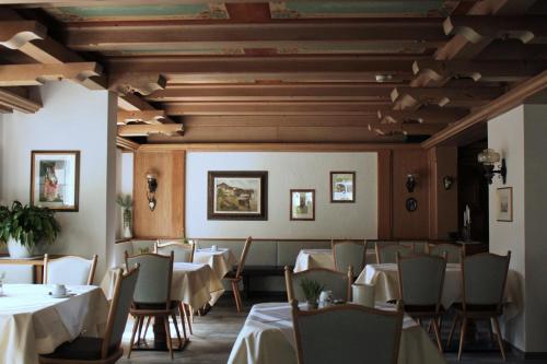 Hotel & Suites Glück Auf في مايرهوفن: غرفة طعام بها طاولات وكراسي وسقوف خشبية