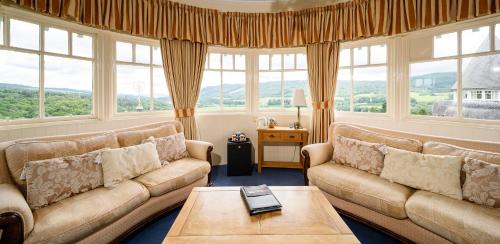 a living room with two couches and a table at The Atholl Palace in Pitlochry