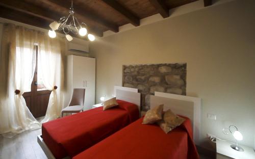 1 dormitorio con 2 camas rojas y ventana en Casa Vacanze Camastra, en Santo Stefano di Camastra