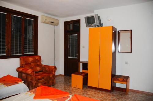 a bedroom with a yellow cabinet and a chair at Villa Velika - Slavi in Velika