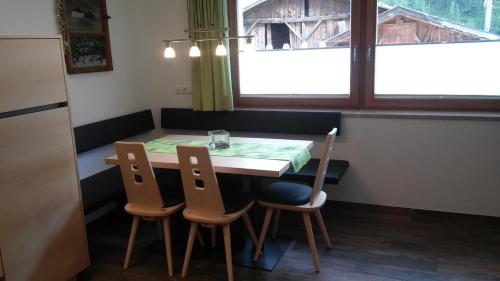 uma mesa e cadeiras num quarto com uma janela em Haus Fliri em Curon Venosta
