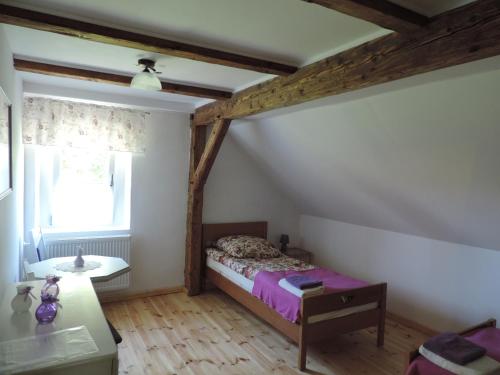 - une petite chambre avec un lit et une fenêtre dans l'établissement Pod Miotełką, à Wleń
