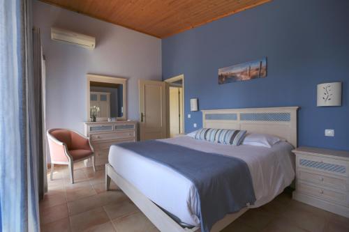 1 dormitorio azul con 1 cama y 1 silla en Quinta do Pinheiro Manso - Holidays Villa - Marinha Beach, en Carvoeiro