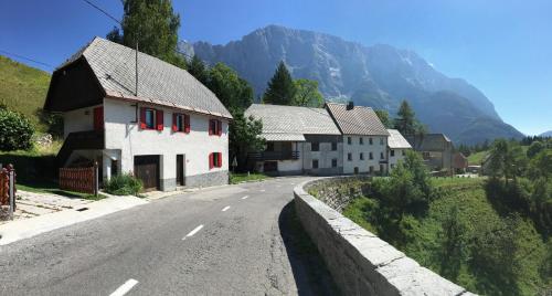 an empty road in a village with mountains in the background at Predel House in Log pod Mangartom