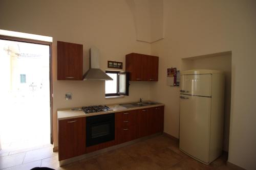 a kitchen with a white refrigerator and a sink at Home Holiday Salento Casa Agrosì Don Camillo in Presicce