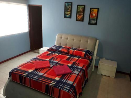 une chambre avec un lit avec une couverture rouge et bleue dans l'établissement Apartamento Perla del Caribe, à Santa Marta