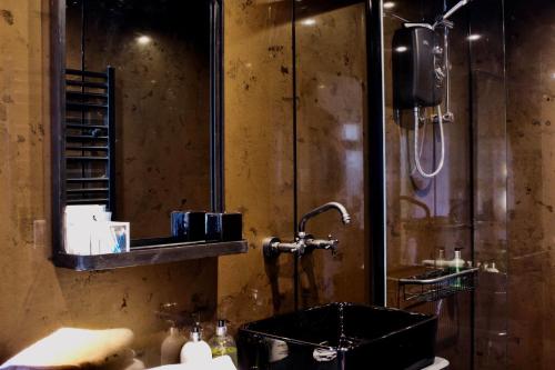 ein Bad mit einem Waschbecken und einer Dusche in der Unterkunft Gower View Luxury Bed & Breakfast in Tenby