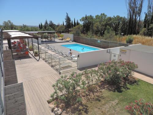 una piscina con terraza de madera y piscina en Studios Nuitée en Provence, en Aix-en-Provence