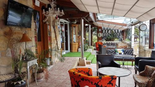 a lobby with chairs and tables and a tv at Hosteria Las Viñas in Noja