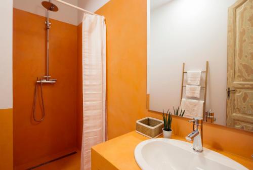 een badkamer met een wastafel en een douche met een spiegel bij OttoH Charm Stay in Valencia