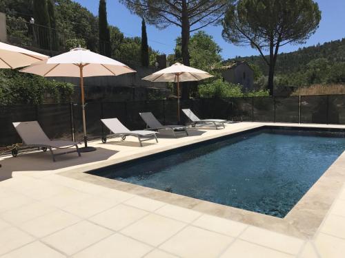 einen Pool mit Stühlen und Sonnenschirmen in der Unterkunft Hôtel du Moulin in Allemagne-en-Provence