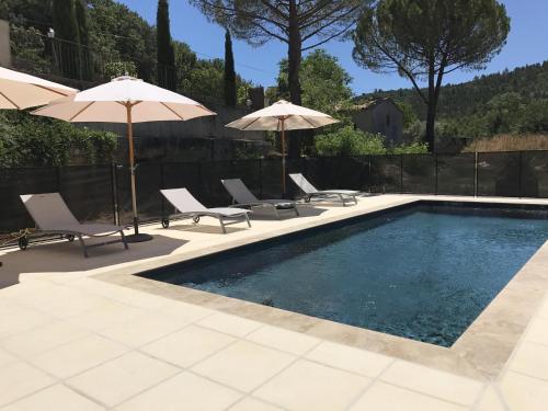 a swimming pool with chairs and umbrellas at Hôtel du Moulin in Allemagne-en-Provence