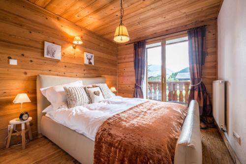 Essert-RomandにあるAppartement Midi Romand proche Morzineの木製の壁のベッドルーム1室(ベッド1台付)