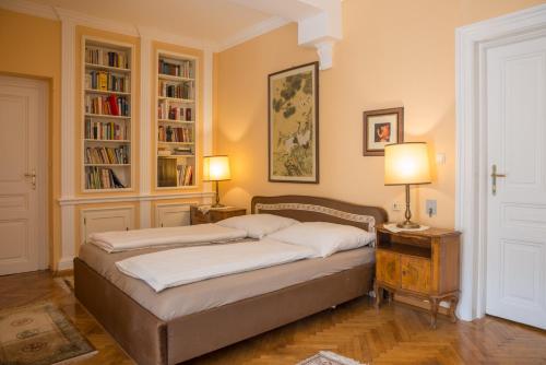 a bedroom with a bed with two lamps and bookshelves at Villa Neuwirth in Greifenstein