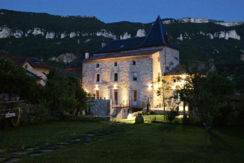 a large stone building with lights on it at night at Les FREJALS in Compeyre