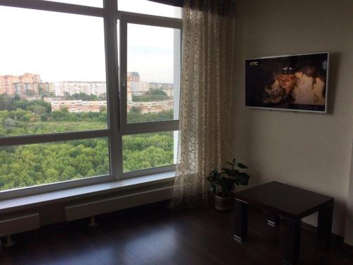 ペルミにあるStudio Apartment near Karuselのリビングルーム(大きな窓、テレビ付)