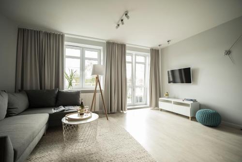 a living room with a couch and a tv at TS Boutique Apartments in Szczecin