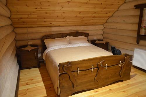 a bedroom with a bed in a log cabin at Gostynna sadyba Kit Bayun in Teterivka