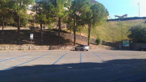 a car parked in a parking lot next to a hill at Pensione Delfino Azzurro in Loreto