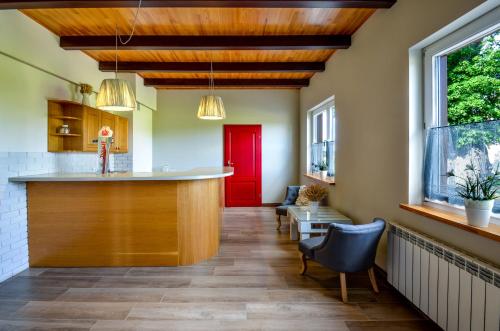 a hallway with a kitchen with a red door at Zielona Przystań in Manasterz