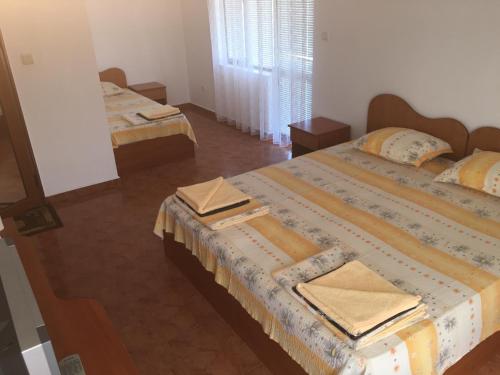 a bedroom with two beds and a mirror at Къща за гости Кадиеви in Primorsko