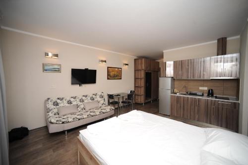 1 dormitorio con 1 cama y cocina con sofá en Orbi Sea Tower Apartment en Batumi