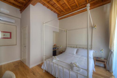 a bedroom with a white canopy bed with a wooden ceiling at Assaporarte in Florence