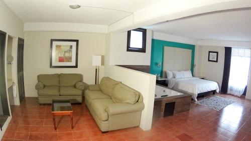 a living room with a couch and a bed at Hotel Santa Fe in Tlatlauquitepec