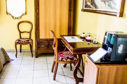 ein Esszimmer mit einem Tisch und einem TV in der Unterkunft Hotel Il Bargellino in Florenz