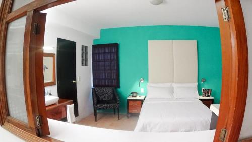 a bedroom with a white bed and a green wall at Hotel Santa Fe in Tlatlauquitepec
