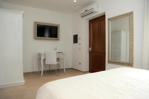 a bedroom with a bed and a table and a mirror at Hypnos Boutique Hotel in San Teodoro