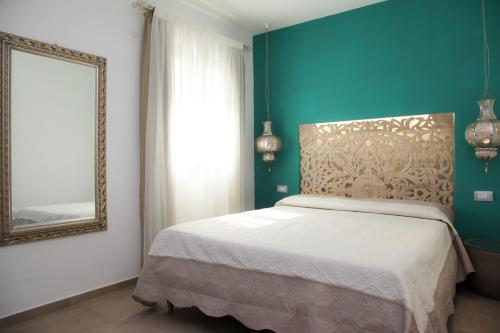 - une chambre avec un lit et un miroir dans l'établissement Hypnos Boutique Hotel, à San Teodoro